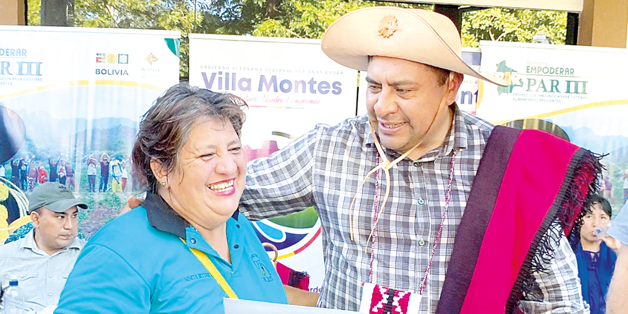 El ministro Yamil Flores entrega un convenio a una autoridad local.