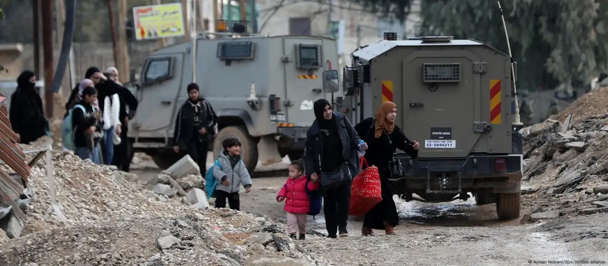 Palestinos llevan sus pertenencias, durante una operación militar israelí en Cisjordania.