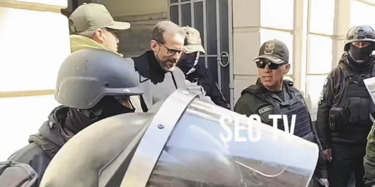 Luis Fernando Camacho sale custodiado por policías de la audiencia.