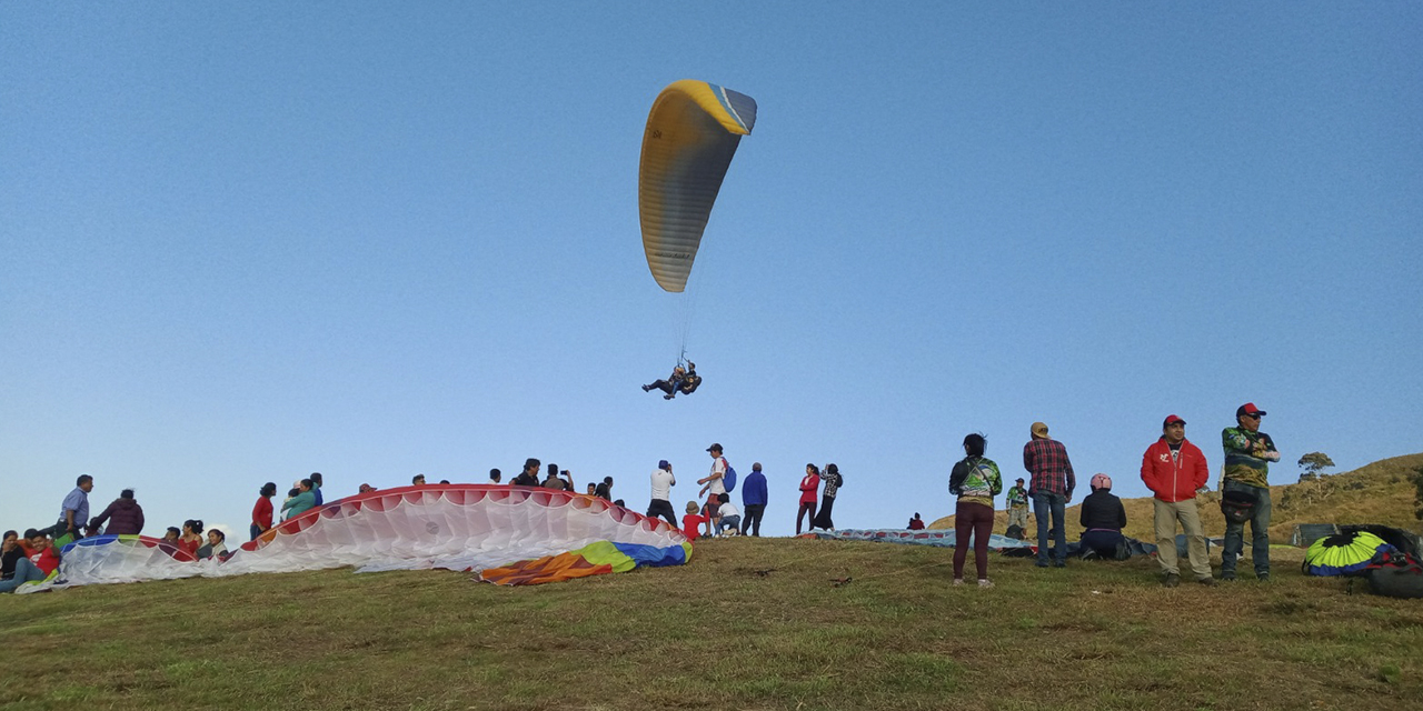 La precisión del aterrizaje en la pista de césped es una cualidad de los participantes en las pruebas de parapente.