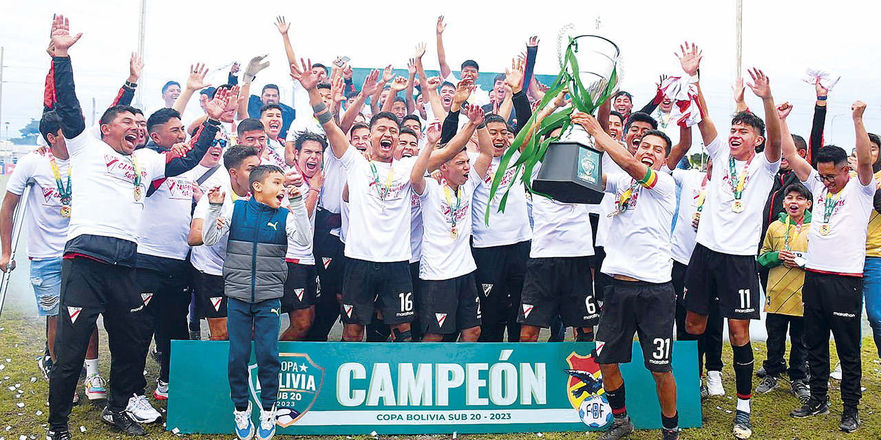 Jugadores del equipo millonario Sub-20 levantan la copa de campeón.