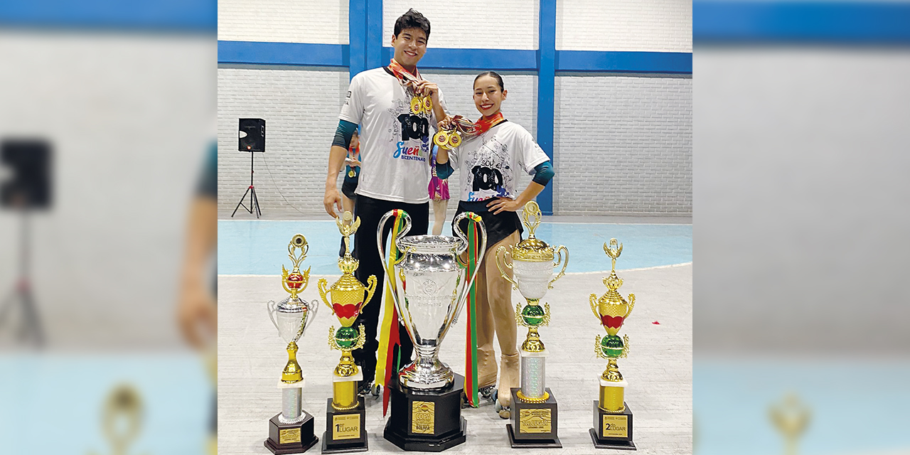 Los patinadores Paulo y Anahí disfrutan de sus medallas y trofeos ganados.