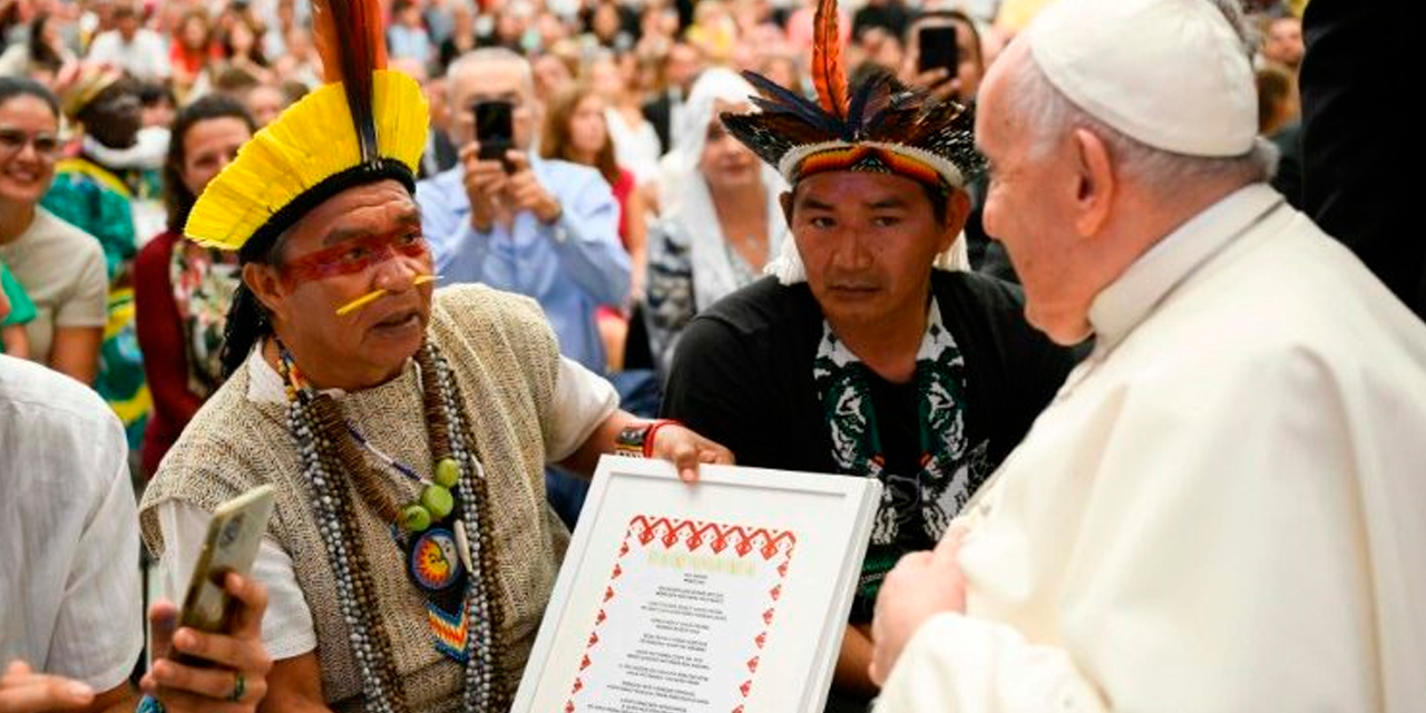 Dos líderes espirituales de la comunidad Yawanawa, en la Amazonia, regalan el Padre Nuestro al Papa. | Foto: Vatican News