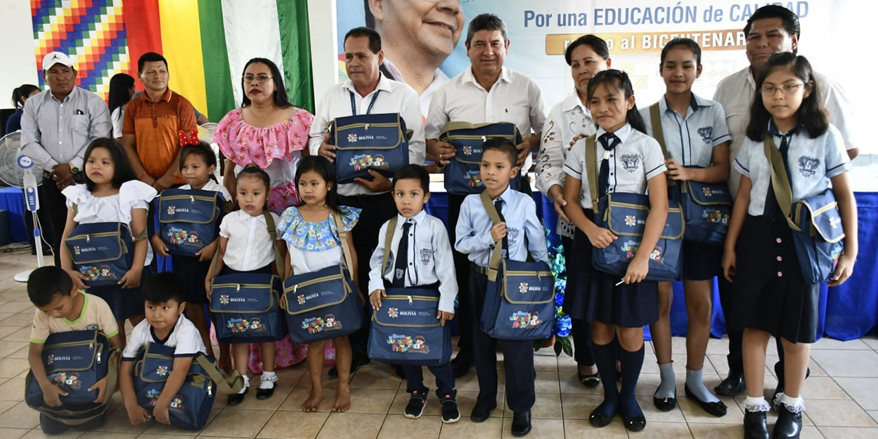 Niños y autoridades estatales muestran el material escolar entregado. 