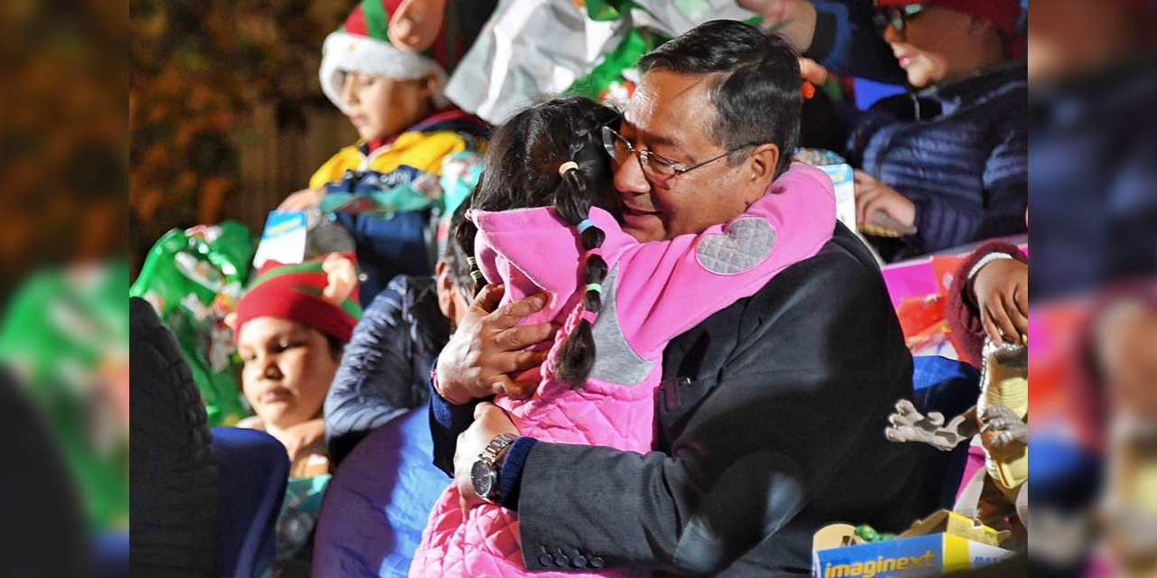 El presidente abraza a una niña en un acto público.