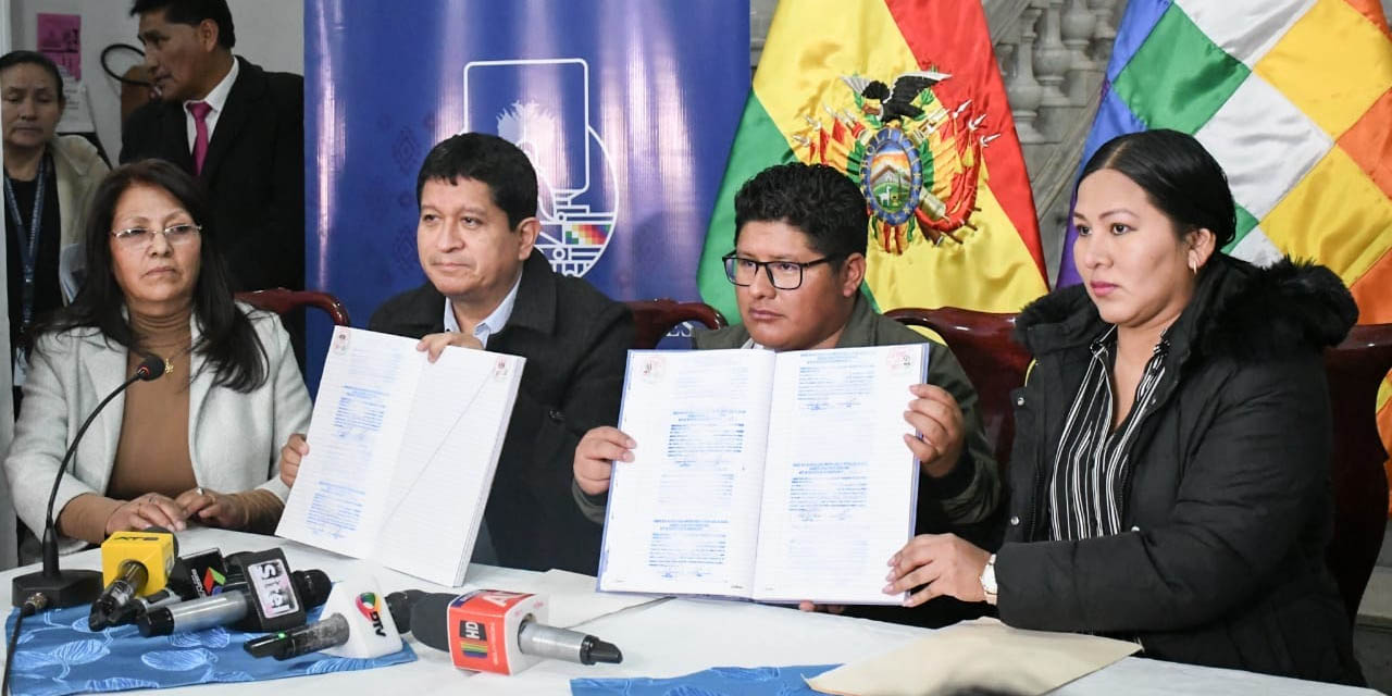 El presidente de la Comisión Mixta de Justicia Plural, Roberto Padilla (centro), muestra el libro de las postulaciones registradas. Foto: Cámara de Senadores