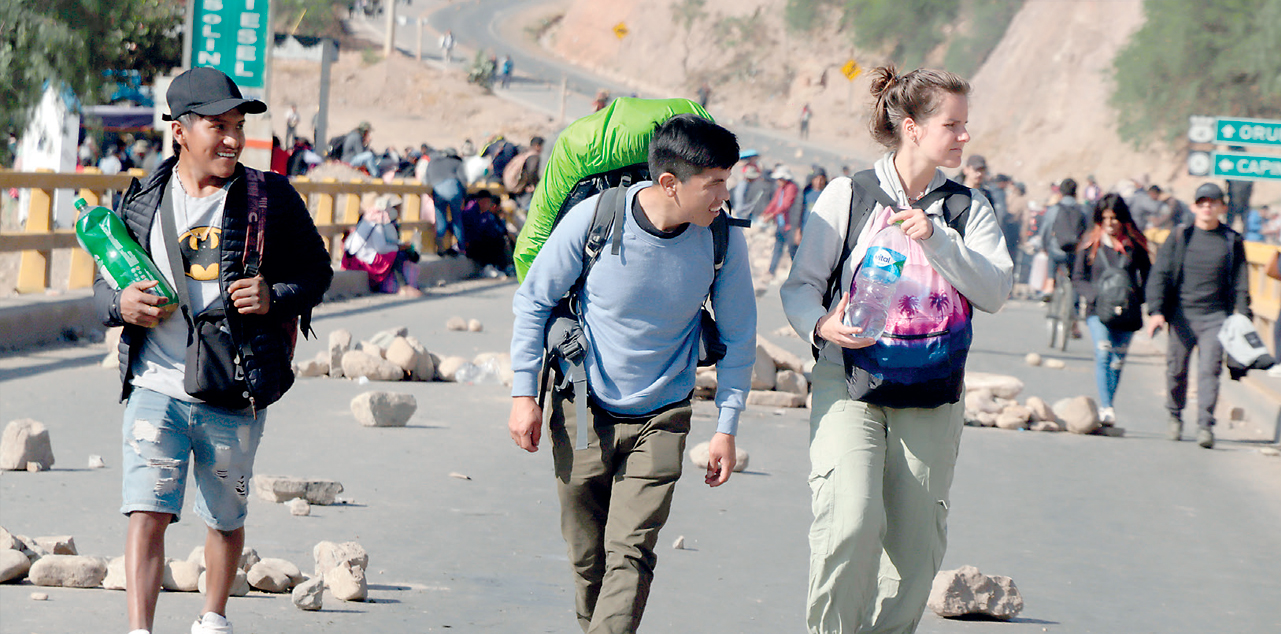 Turistas caminan por una vía bloqueada. // FOTO: RRSS