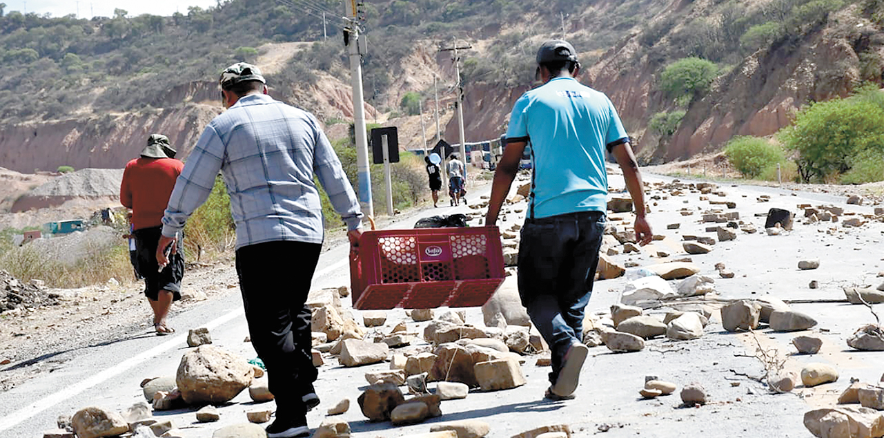 Dos personas caminan por un punto de bloqueo. Foto: RRSS